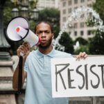 Protester holding a sign reading RESIST
