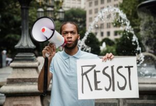 Protester holding a sign reading RESIST